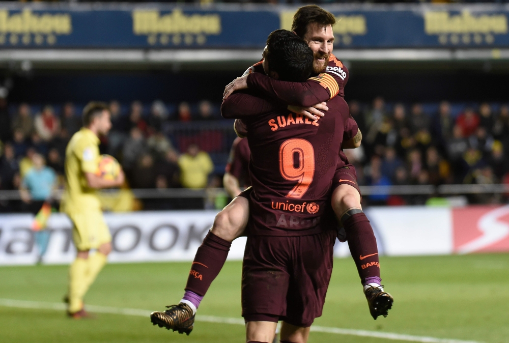Barcelona's Argentinian forward Lionel Messi (L) celebrates  with Barcelona's Uruguayan forward Luis Suarez after scoring during the Spanish league football match against Villarreal CF at La Ceramica stadium in Vila-real on Sunday. — AFP