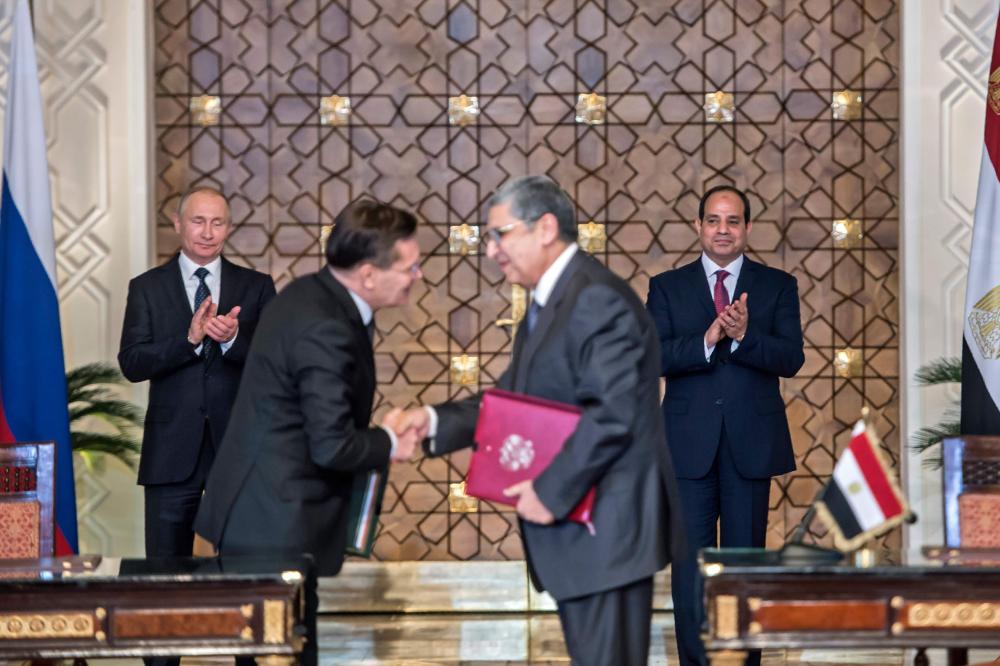 Egyptian president Abdel Fattah el-Sisi (back-R) and his Russian counterpart Vladimir Putin (back-L) applaud as Egypt's Electricity and Renewable Energy Minister Mohamed Shaker (R), shakes hands with Alexei Likkhachev, the director general of Russia's Atomic Energy Corporation Rosatom, after signing a bilateral agreement in Cairo on Monday. — AFP 