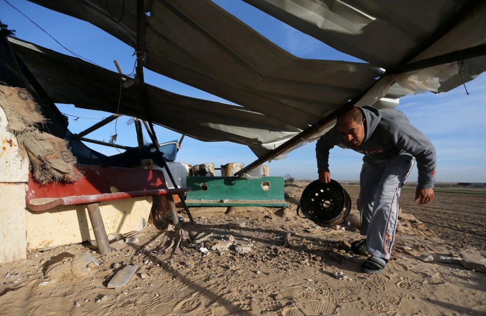 A Palestinian man inspects an area that was hit in an Israeli air strike in the southern Gaza Strip on Tuesday. — Reuters