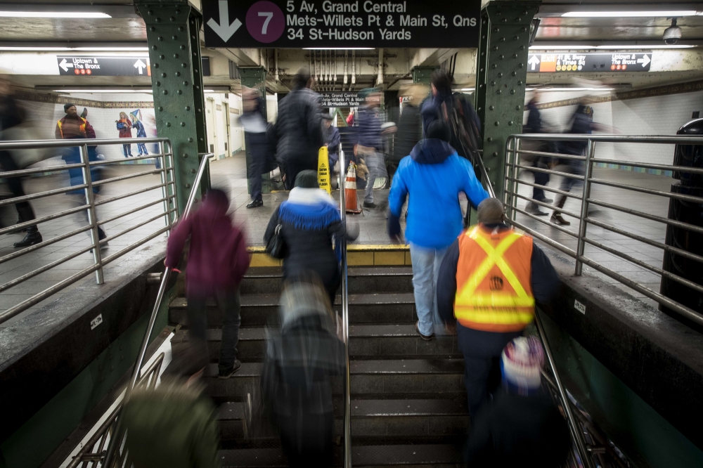 Commuters exit a train during the evening rush hour near the tunnel that connects the Times Square subway station to the Port Authority Bus Terminal in New York City on Monday. — AFP