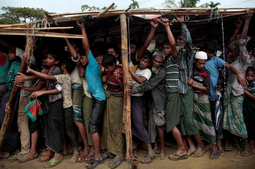 Rohingya refugees jostle as they line up for a blanket distribution under heavy rainfall at the Balukhali camp near Cox's Bazar, Bangladesh, on Monday. — Reuters