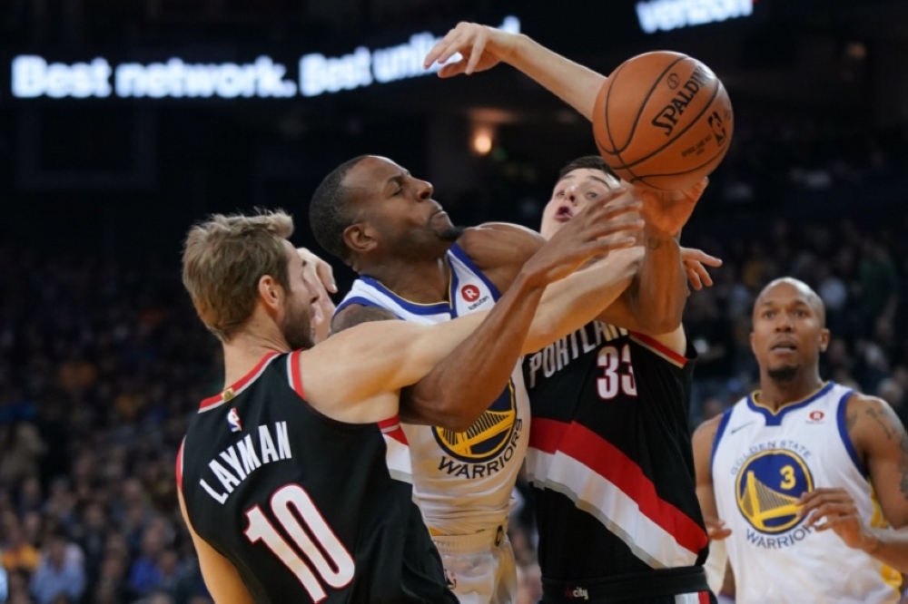 Golden State Warriors forward Andre Iguodala (9) is fouled while being defended by Portland Trail Blazers forward Jake Layman (10) and enter Zach Collins (33) during the first quarter at Oracle Arena. — Reuters