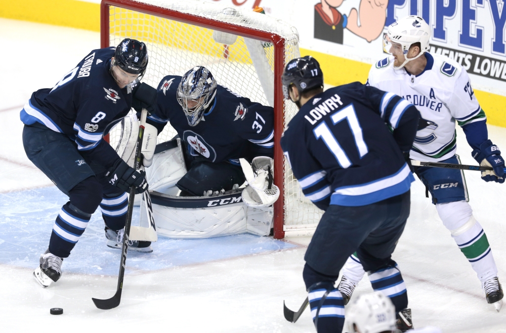 Winnipeg Jets defenseman Jacob Trouba (8) picks up a rebound in front of Winnipeg Jets goalie Connor Hellebuyck (37) in first period action at Bell MTS Centre. — Reuters