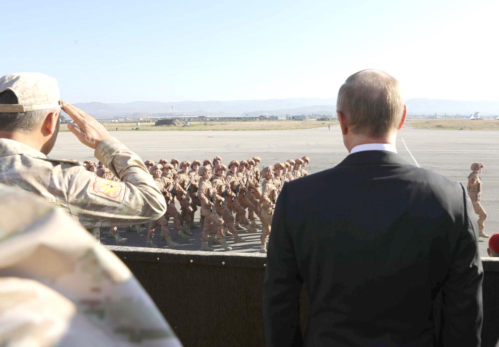 

Russian President Vladimir Putin (R) and Defense Minister Sergei Shoigu watch servicemen passing by as they visit the Hmeymim air base in Latakia Province, Syria, on Monday. — Reuters