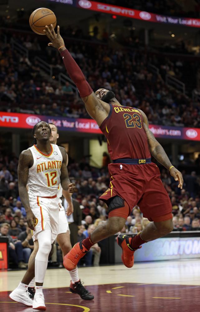 Cleveland Cavaliers’ LeBron James (R) shoots as Atlanta Hawks’ Taurean Prince looks on during their NBA game in Cleveland Tuesday. — AP 