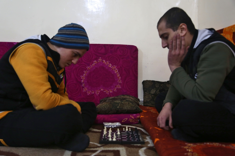 Mohammed Haj Ahmad (R), 23, plays chess with his roommate at the Syrian Center for Countering Extremist Ideology in the Syrian town of Marea, in the northern Aleppo district. — AFP