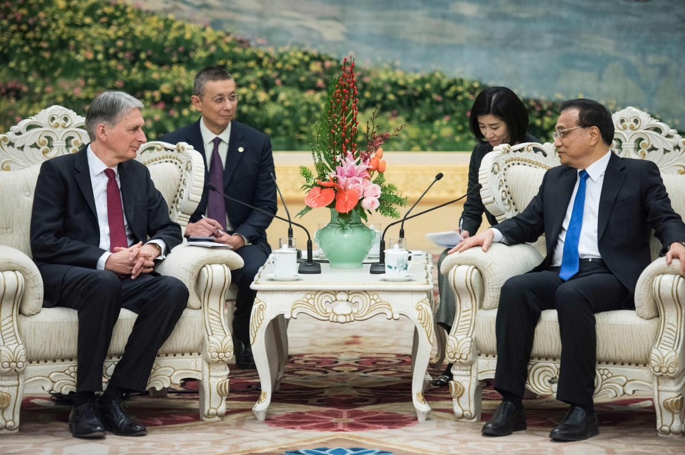 China's Premier Li Keqian speaks with Britain's Chancellor of the Exchequer Philip Hammond during a meeting at the Great Hall of the People in Beijing on Friday. — AFP