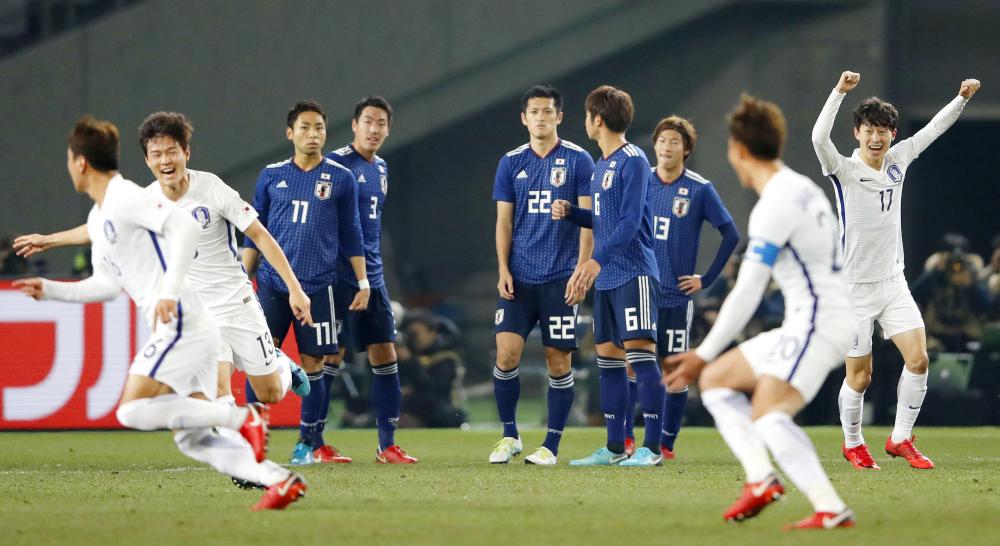 South Korea’s players celebrate after scoring a goal against Japan at the East Asian Championship in Tokyo Saturday. — AP