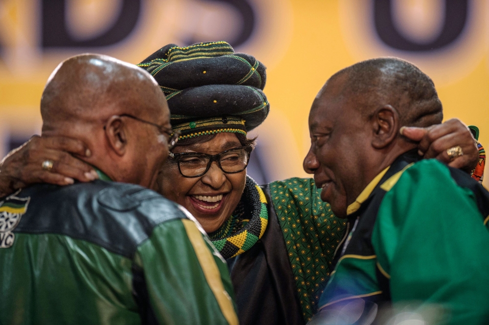 The former wife of the late South African President Nelson Mandela, Winnie Mandela, center, hugs South African President Jacob Zuma, left, and Deputy President Cyril Ramaphosa as they attend the 54th ANC National Conference at the NASREC Expo Centre in Johannesburg on Saturday. — AFP