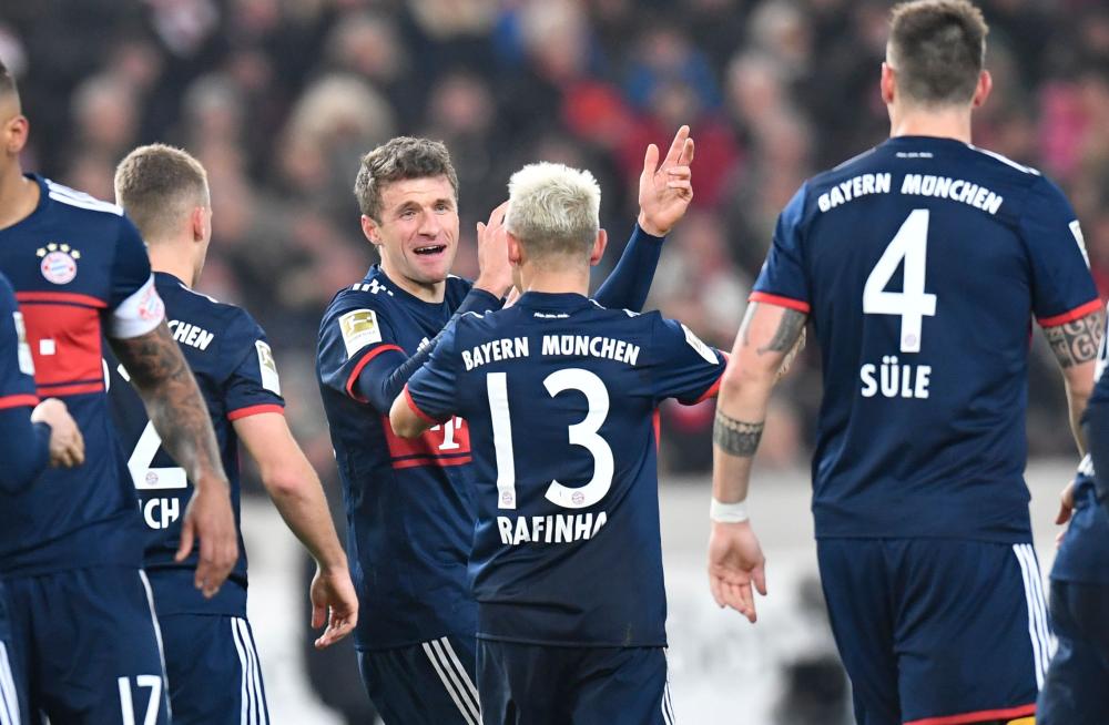 Munich's midfielder Thomas Mueller (C) celebrates with teammates after he scored during the German first division Bundesliga football match against VfB Stuttgart in Stuttgart Saturday. — AFP