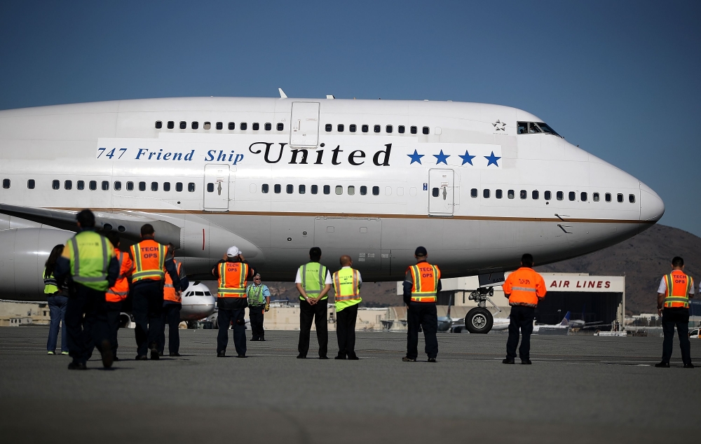 United Airlines workers look on as United Airlines flight 747 prepares to take off from San Francisco International Airport for its final flight to Honolulu, Hawaii, on Nov. 7, 2017 in San Francisco, California. — AFP