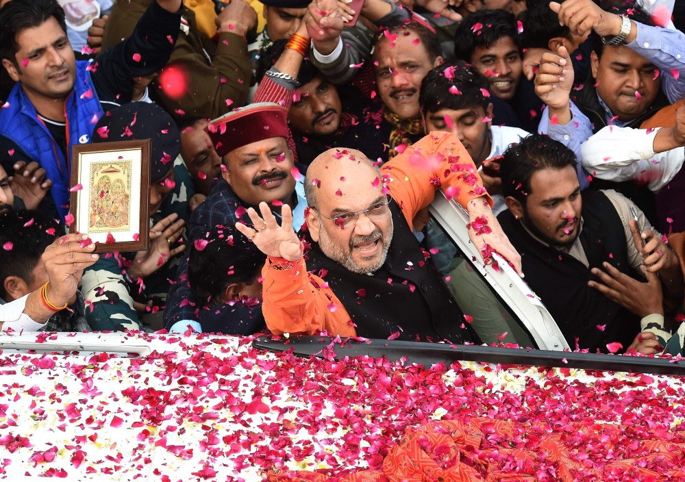 Indian Bharatiya Janata Party (BJP) President Amit Shah, center, shows the victory sign to supporters as he arrives to address a press conference at the party headquarters in New Delhi on Monday. — AFP