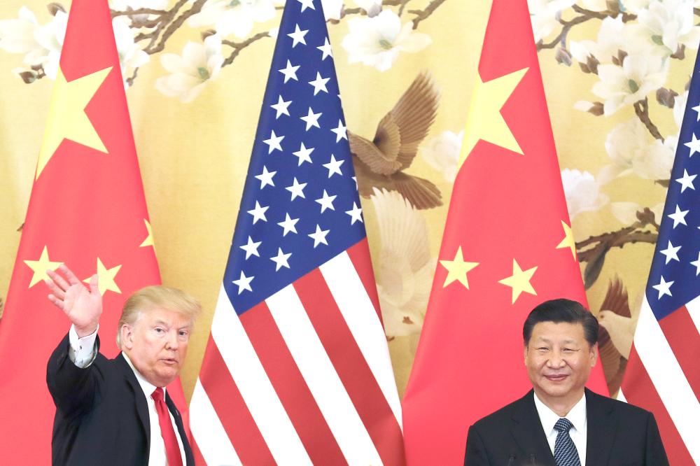 US President Donald Trump waves next to Chinese President Xi Jinping after attending a joint press conference at the Great Hall of the People in Beijing in this Nov. 9, 2017 file photo. — AP