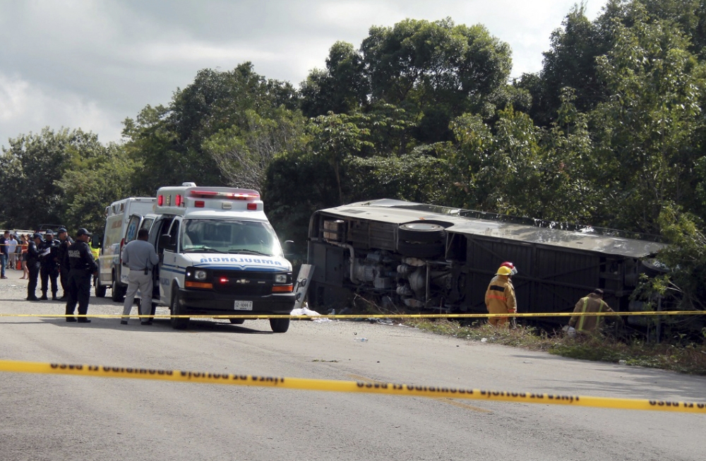 An ambulance sits parked next to an overturned bus in Mahahual, Quintana Roo state, Mexico, on Tuesday. — AP