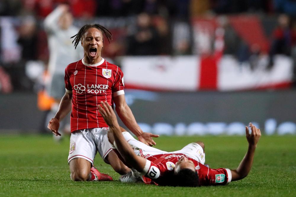 Bristol City’s Bobby Reid and Korey Smith celebrate their winner against Manchester United during their quarterfinal match of the English League Cup Ashton Gate Stadium in Bristol Wednesday. — Reuters
