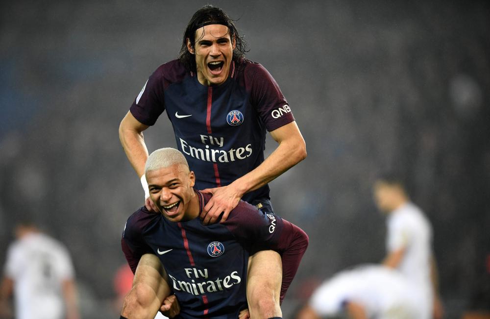 Paris Saint-Germain’s French forward Kylian MBappe celebrates with teammate Edinson Cavani (top) after scoring during the French L1 football match against Caen at the Parc des Princes Stadium in Paris Wednesday. — AFP 