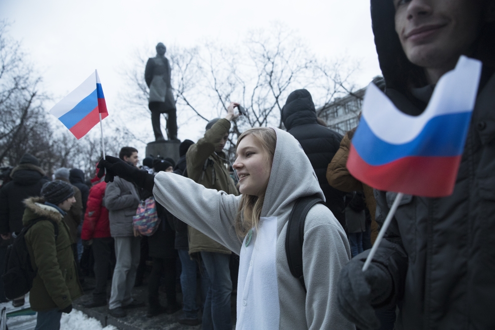 Russian opposition activists hold Russian national flags as they gather at a park in Moscow, Russia, on Sunday. — AP