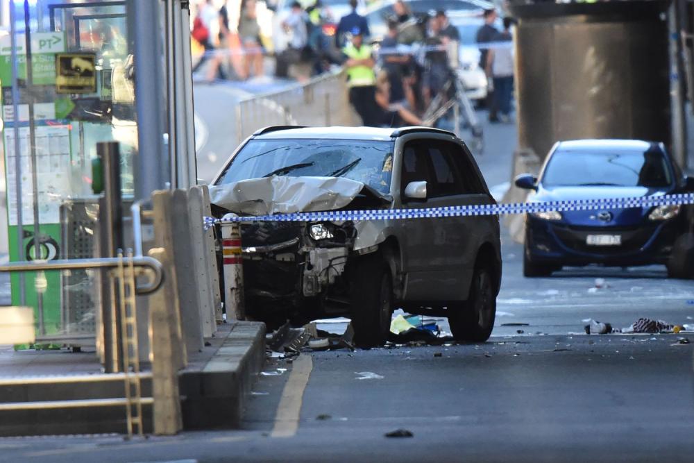 A white SUV sits in the middle of the road as police and emergency personnel work at the scene of where a car ran over pedestrians in Flinders Street in Melbourne, Australia on Dec. 21, 2017. - AFP