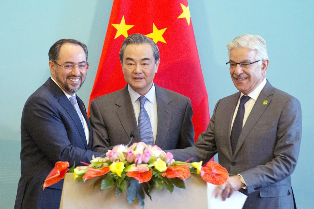 Afghanistan Foreign Minister Salahuddin Rabbani, left, Chinese Foreign Minister Wang Yi, center, and Pakistani Foreign Minister Khawaja Asif hold hands to pose for a photo after a press conference for the 1st China-Afghanistan-Pakistan Foreign Ministers’ Dialogue held in Beijing, China, on Tuesday. — AP