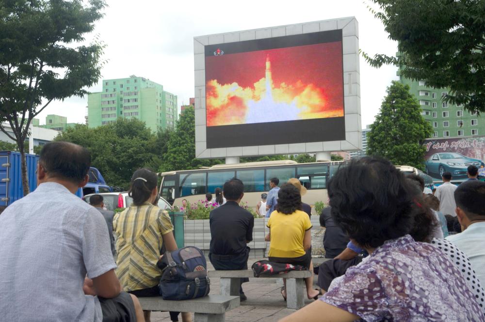 People watch as coverage of an ICBM missile test is displayed on a screen in a public square in Pyongyang in this July 29, 2017 file photo. — AFP
