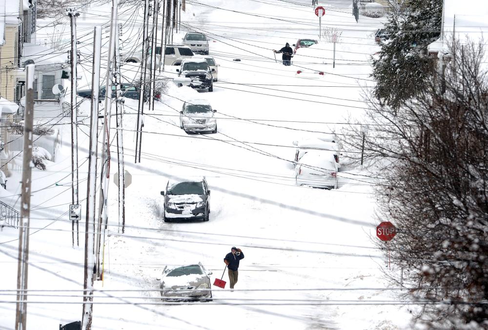Erie, Pennsylvania, residents on East 24th Street dig out on Tuesday after a record two-day snowfall. — AP