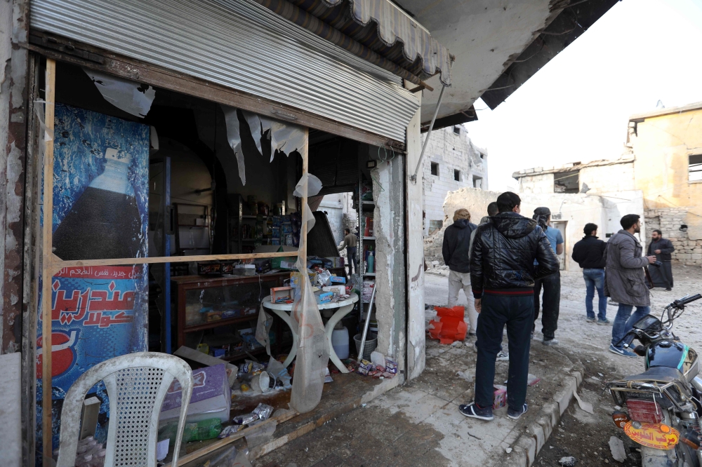Syrians inspect a damaged shop following reported air stikres in the city of Maarat Al-Numan in the Idlib province. — AFP