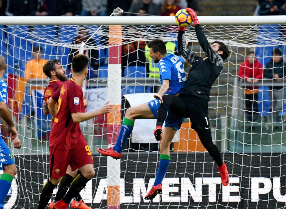 AS Roma's goalkeeper from Brazil Allison (R) controls the ball over Sassuolo's defender from Italy Francesco Acerbi during their Italian Serie A football match at the Olympic Stadium in Rome Saturday. — AFP 