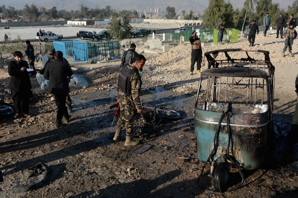 Afghan security personnel inspect the scene of a suicide attack that targeted a funeral ceremony in Jalalabad on Sunday. — AFP