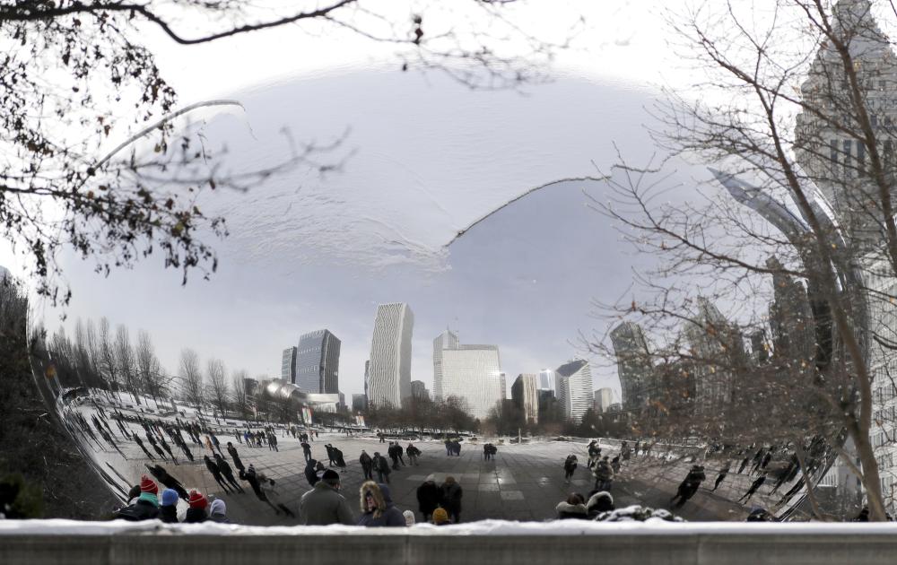 People visit a snow-covered Cloud Gate at Millennium Park in Chicago on Sunday. — AP