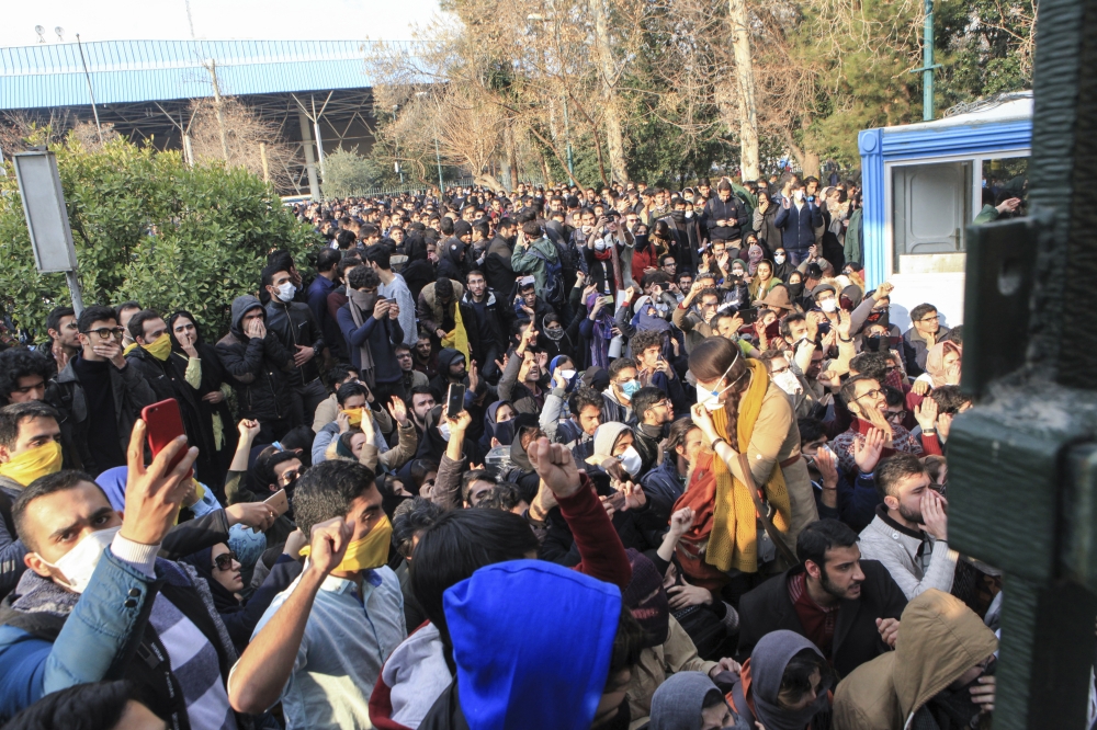 University students attend a protest inside Tehran University while anti-riot Iranian police prevent them to join other protesters, in Tehran. — AP