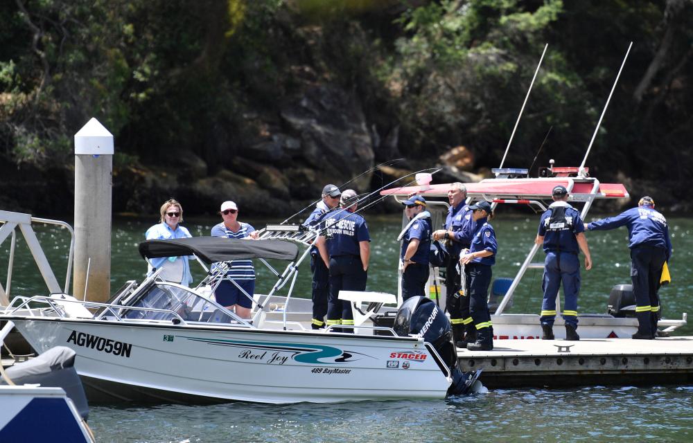 Australian Fire & Rescue personnel stand near their boats after visiting the scene where a seaplane crashed on Sunday killing six people, at Apple Tree Bay boat ramp located on the Hawkesbury River, north of Sydney in Australia, on Tuesday. — Reuters