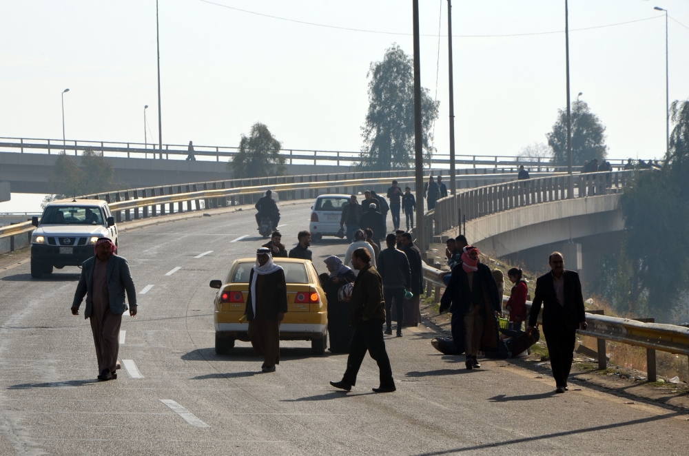 Iraqis preparing to cross one of the last two bridges open for civilians in Iraq's second city Mosul.  — AFP