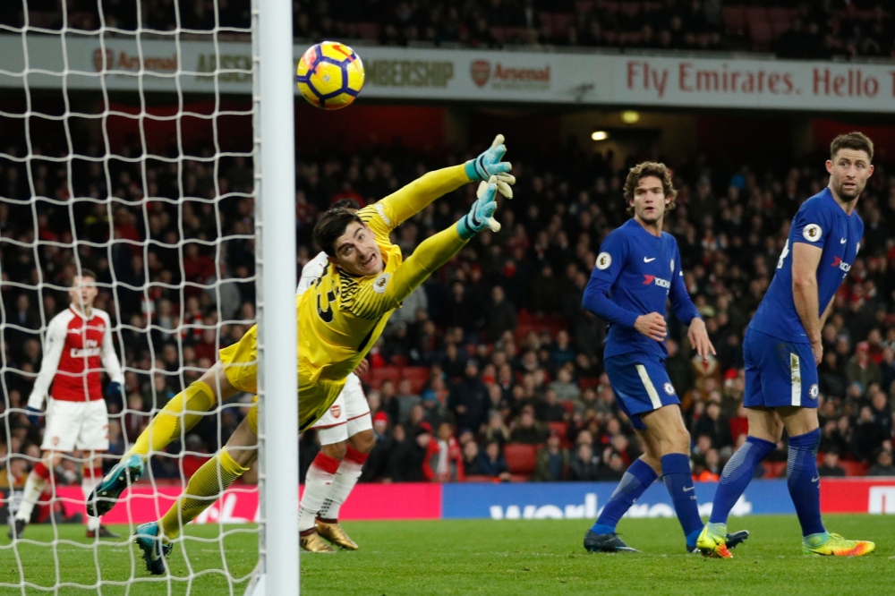 Chelsea's Belgian goalkeeper Thibaut Courtois (C) fails to stop a shot by Arsenal's Spanish defender Hector Bellerin to make it 2-2 during the English Premier League football match at the Emirates Stadium in London on Wednesday. — AFP