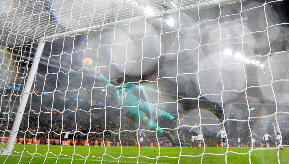 West Ham United's Spanish goalkeeper Adrian (C) dives but fails to stop the shot from Tottenham Hotspur's South Korean striker Son Heung-Min for Tottenham's equalizing goal during the English Premier League football match at Wembley Stadium in London, on Thursday. — AFP