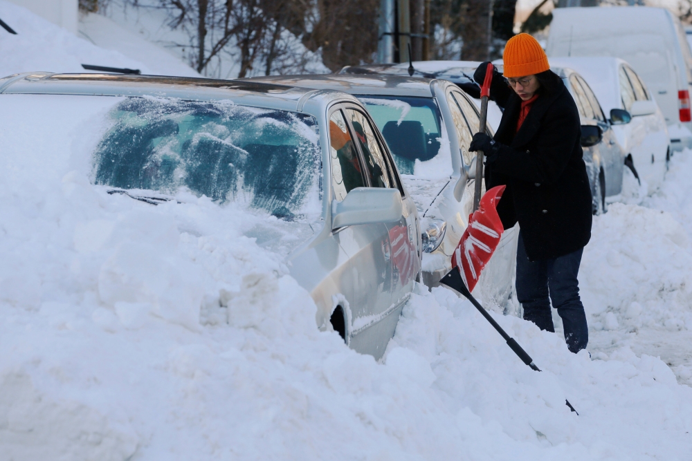 A woman digs out her car following winter snow storm Grayson in Boston, Massachusetts, on Friday. — Reuters