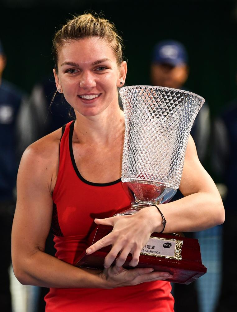 Simona Halep of Romania celebrates with the trophy at the WTA Shenzhen Open Tennis Tournament Saturday. — AFP
