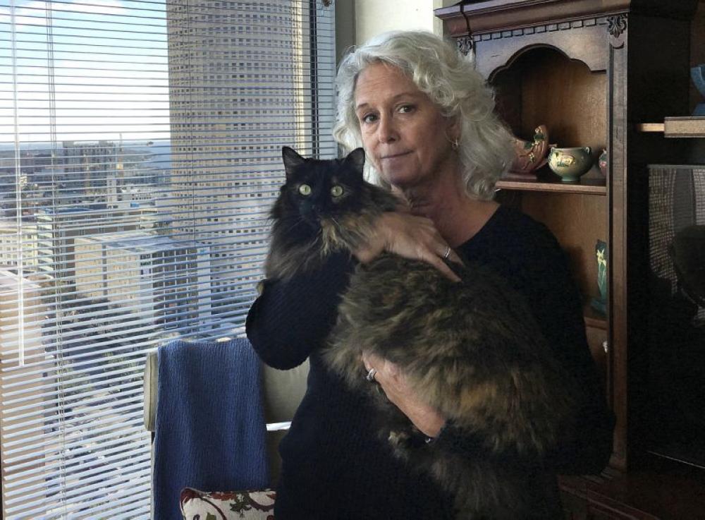 Christine Lee holds her long-haired house cat, Calli, in her condominium in downtown Tampa, Florida on Friday. In a lawsuit, a contractor alleges that he was attacked by a bobcat while working in the condo. - AP