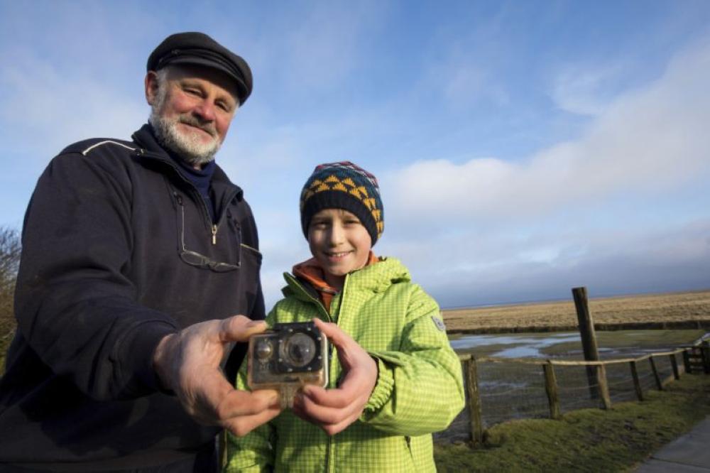 Britain's William Etherton, right, and resident Roland Spreer hold a camera on the North Sea island of Suederoog, Germany on Sunday. - AP