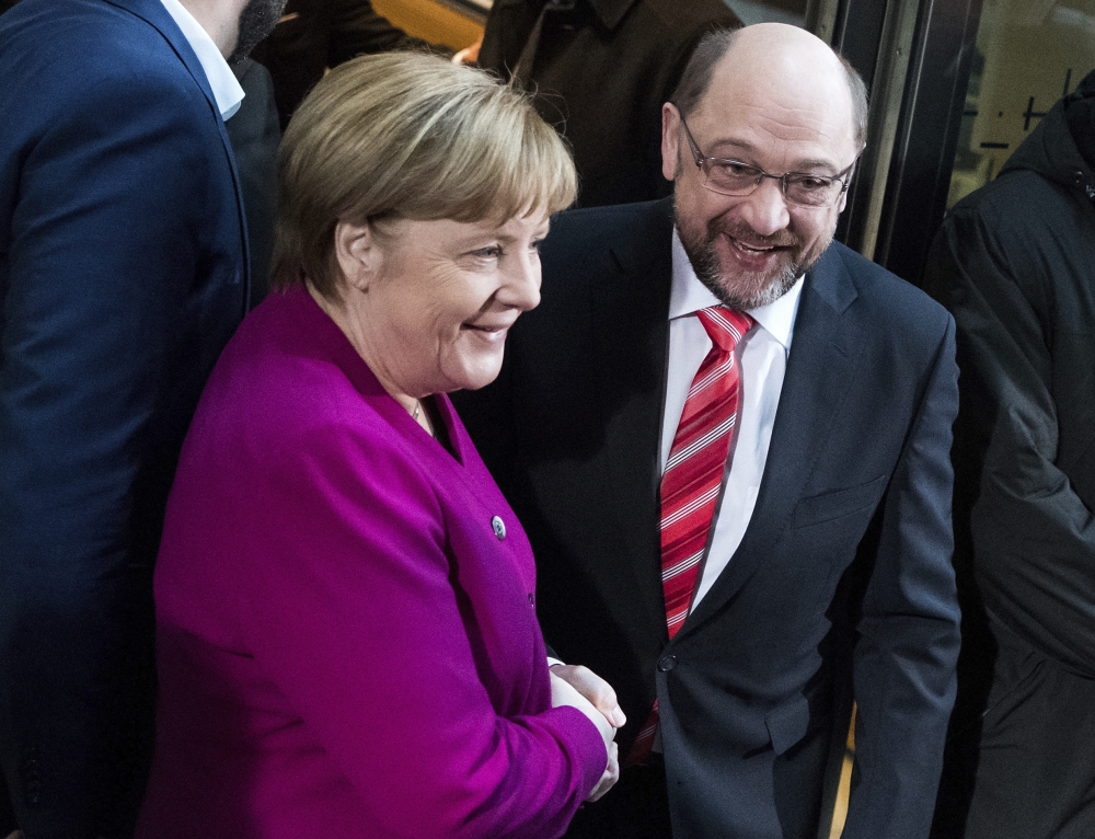 German chancellor and head of the Christian Democrats, Angela Merkel, left, and the leader of Germany’s Social Democratic party, Martin Schulz, shake hands in Berlin on Sunday. — AP