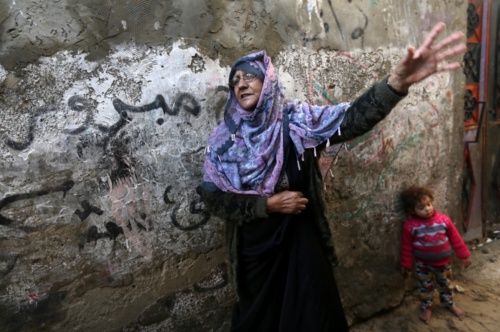 A Palestinian woman stands outside her house in Khan Younis refugee camp in the southern Gaza Strip on Sunday. — Reuters