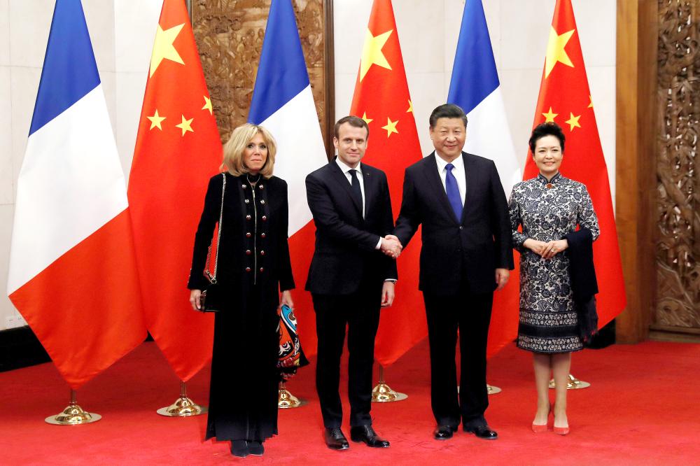 French President Emmanuel Macron and his wife Brigitte Macron pose with China’s President Xi Jinping and his wife Peng Liyuan during their meeting in Beijing, China, on Monday. — Reuters