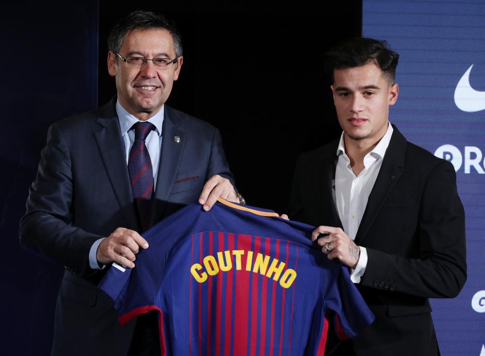 Barcelona’s new signing Philippe Coutinho and Barcelona President Josep Maria Bartomeu pose with the club shirt at Camp Nou, Barcelona, Monday. — Reuters