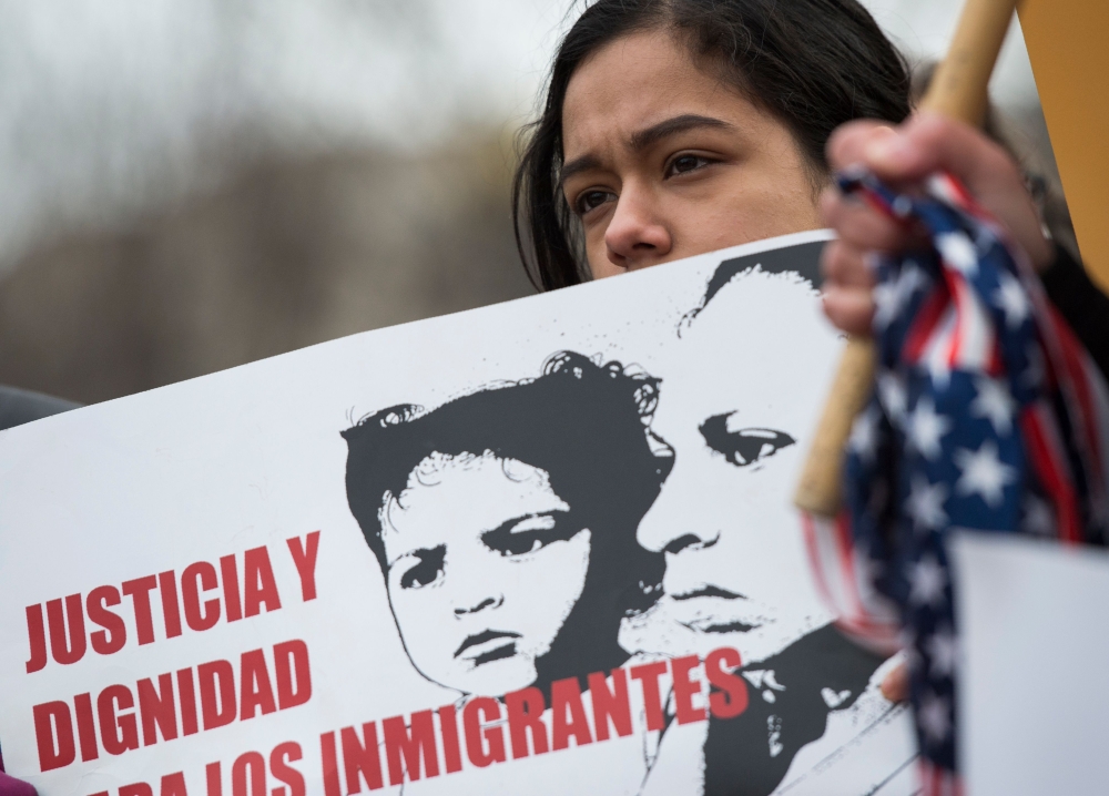 A young girl looks on as other immigrants and activists protest near the White House to demand that the Department of Homeland Security extend Temporary Protected Status (TPS) for more than 195,000 Salvadorans in Washington on Monday. — AFP