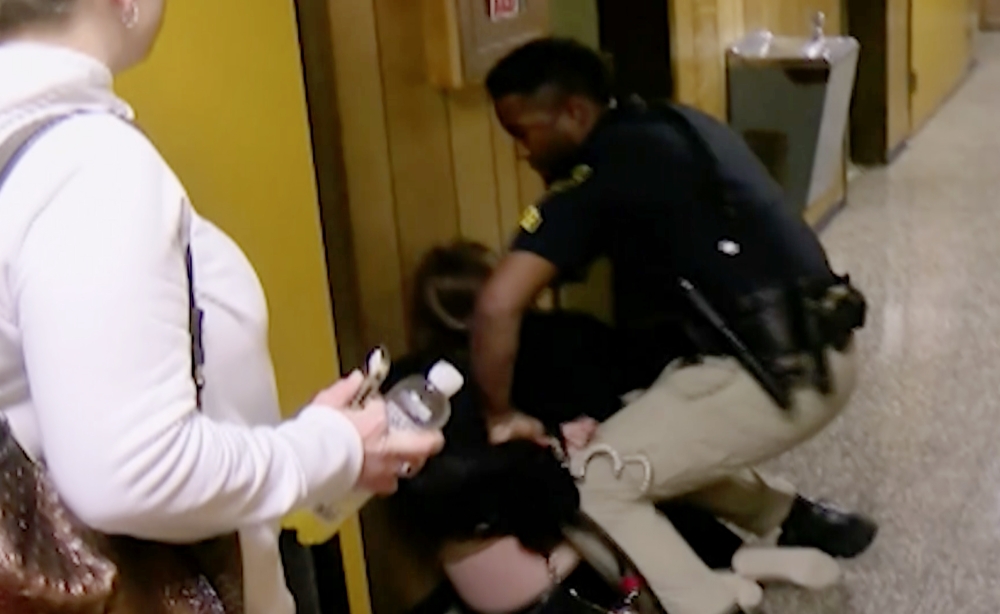 Middle-school English teacher Deyshia Hargrave is handcuffed by a city marshal after complying with a marshal's orders to leave a Vermilion Parish School Board meeting in Abbeville, La., west of New Orleans on Monday. — AP