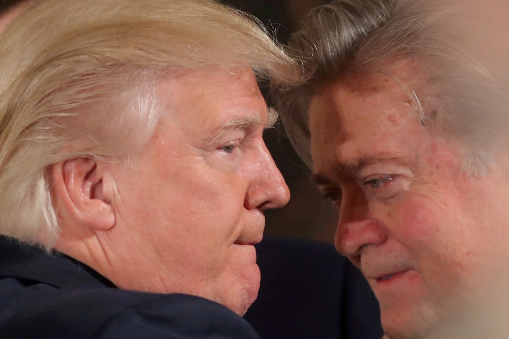 US President Donald Trump talks to chief strategist Steve Bannon during a swearing in ceremony for senior staff at the White House in Washington in this Jan. 22, 2017 file photo. — Reuters