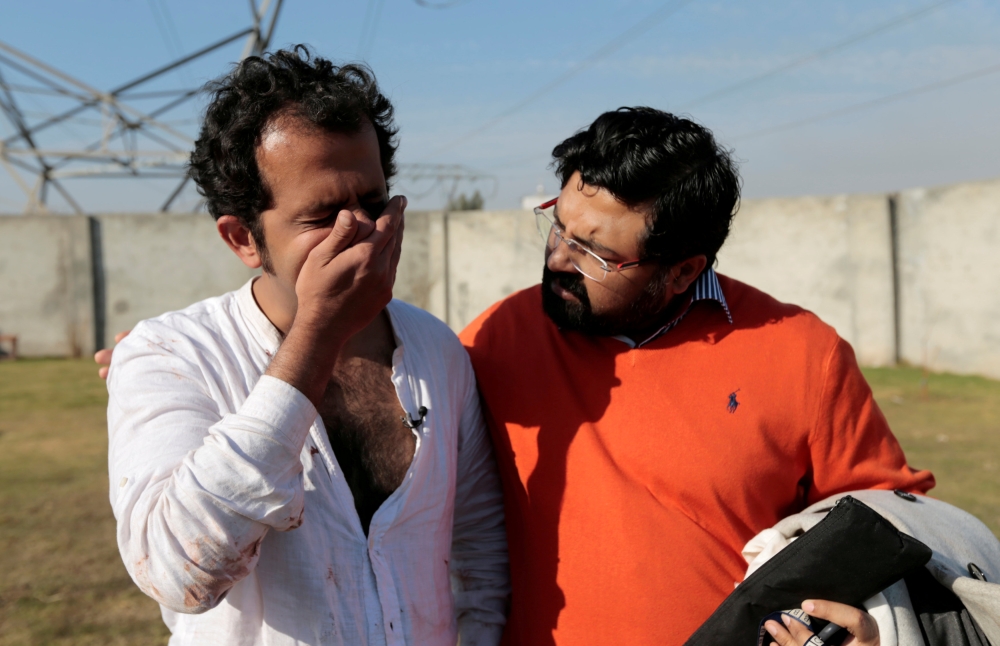 A friend comforts Pakistani journalist Taha Siddiqui, who escaped a kidnapping attempt, after he made a statement to police in Rawalpindi, Pakistan, on Wednesday. — Reuters