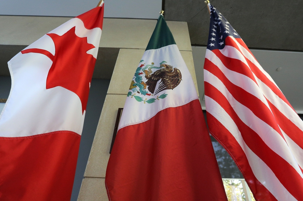 This file photo shows the Mexican, US and  Canadian flags in the lobby where the third round of the NAFTA renegotiations took place in Ottawa, Ontario. In the run-up to the latest North American Free Trade Agreement (NAFTA) renegotiations, friction is high between Canada and the US — with Ottawa determined not to bow to the Trump administration's demands, while Mexico opts for a more measured approach.Irritated by countervailing duties imposed on its exports to the US, Canada has called upon the World Trade Organization (WTO) to denounce protectionist trade practices — which it believes contradict international rules and affect other countries such as China. — AFP