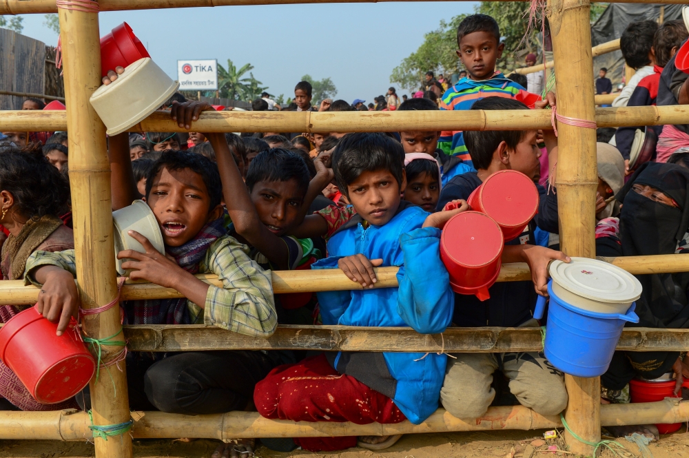 Rohingya Muslim refugees wait for food aid at Thankhali refugee camp in Bangladesh's Ukhia district on Friday. About 655,000 Rohingya have escaped to Bangladesh since August 2017. — AFP