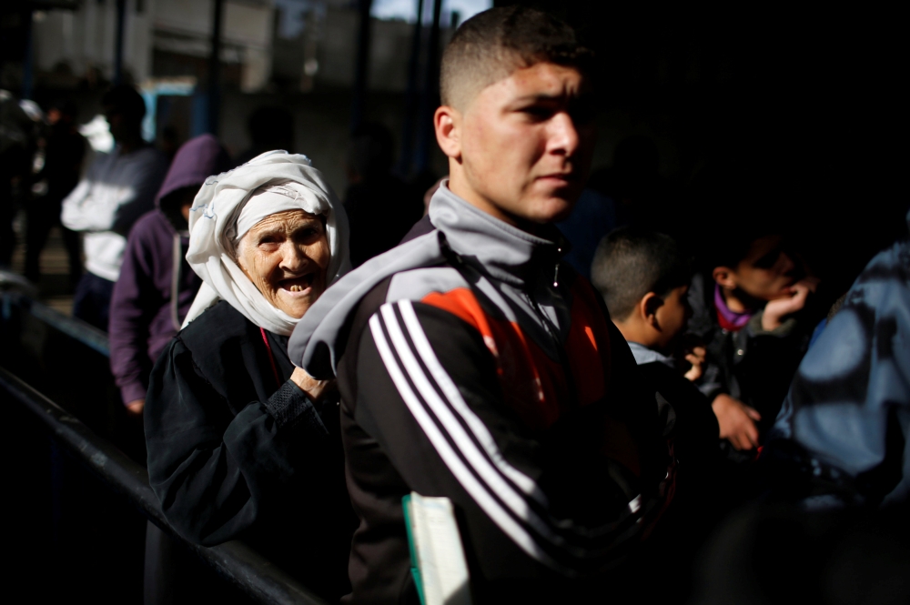 A Palestinian refugee woman waits to receive aid at a United Nations food distribution center in Al-Shati refugee camp in Gaza City. — Reuters