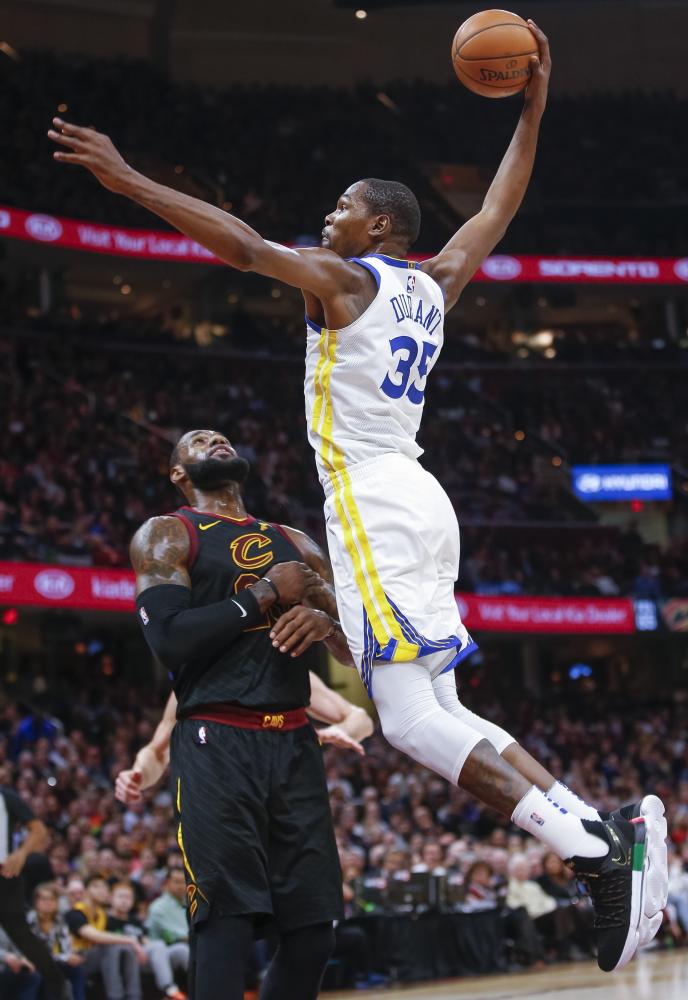 Kevin Durant of the Golden State Warriors goes up for the dunk over LeBron James of the Cleveland Cavaliers during their NBA game at Quicken Loans Arena Monday. — AFP